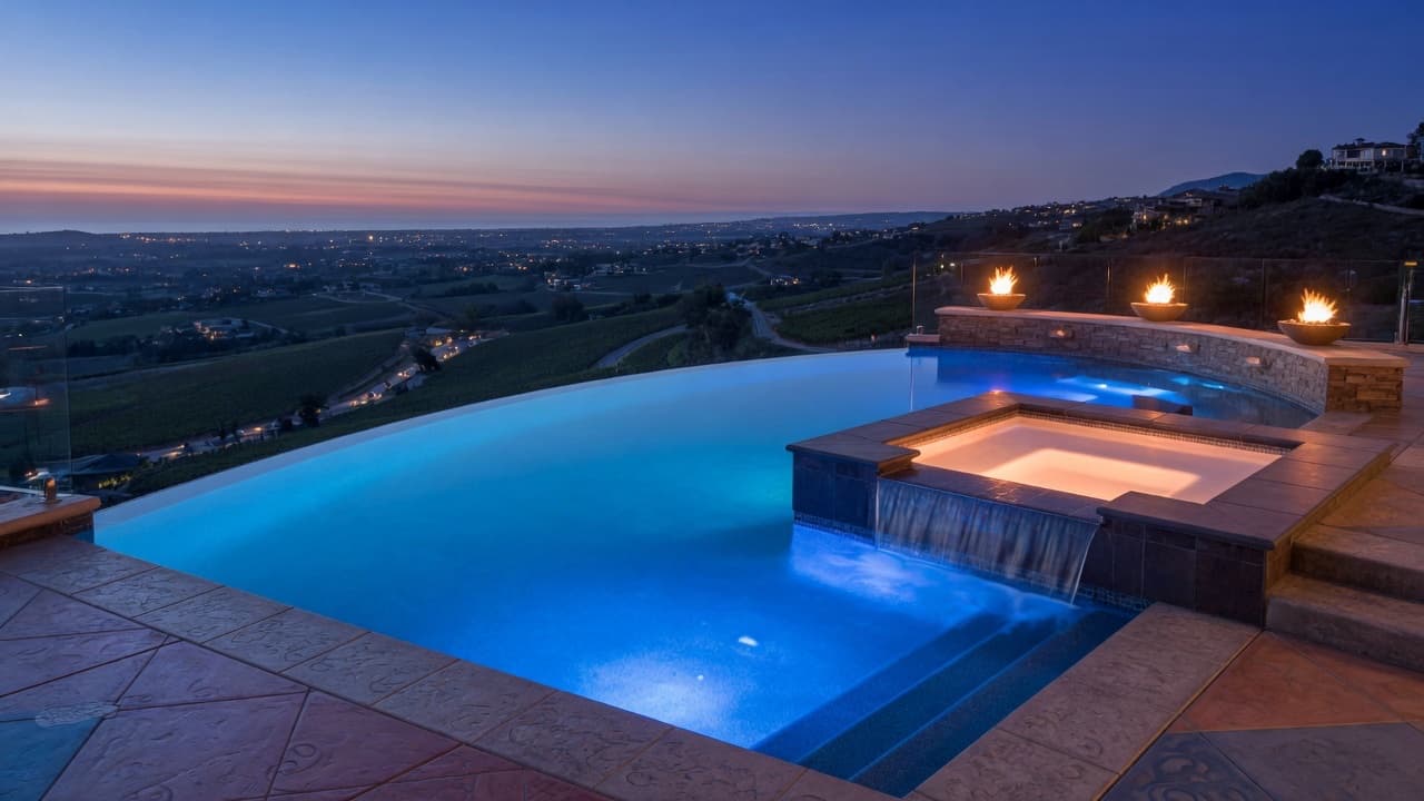 A CnC vanishing-edge pool and spa at dusk, overlooking the valley